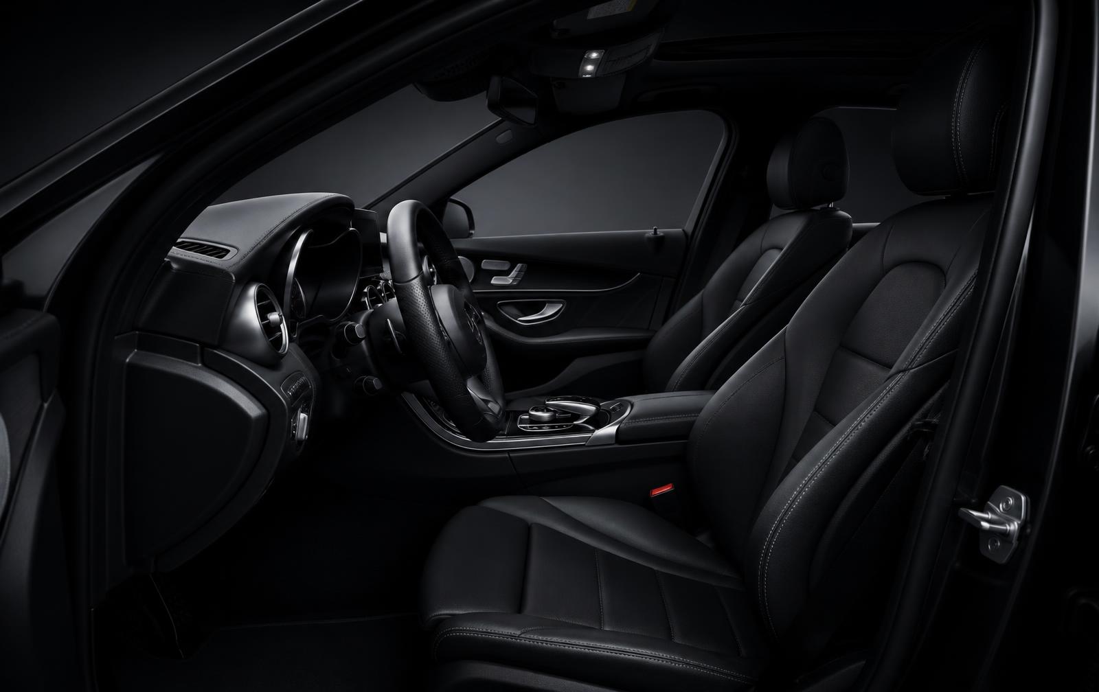 Clean black leather cabin viewed from the open driver doorway